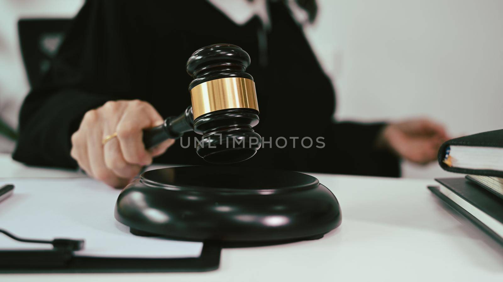 Close up view mature female judge in robe gown uniform holding a gavel in hand. Lawyer, justice and law and attorney concept.