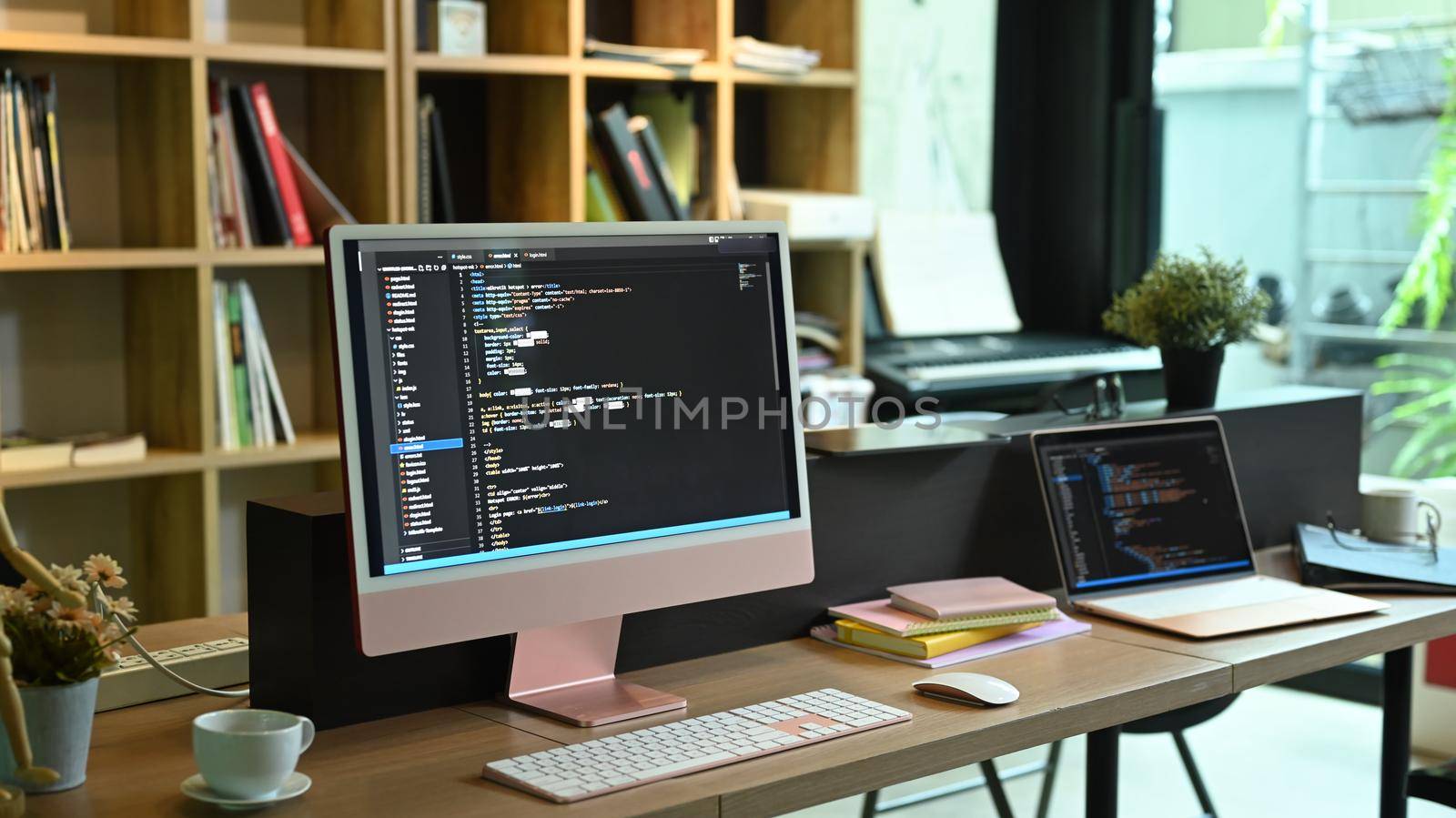 Computer pc and laptop with programming code on screens at software development company.