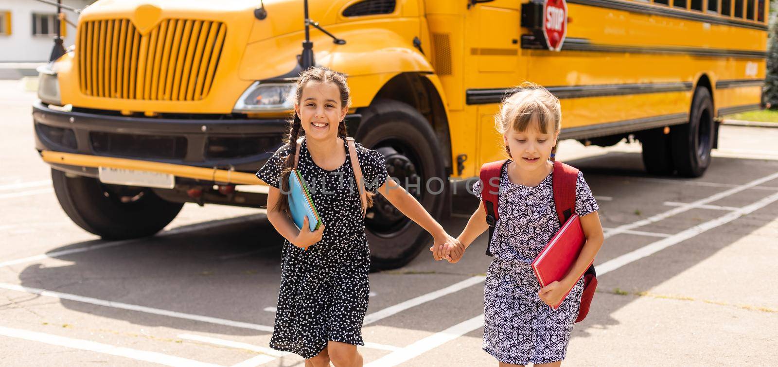 Lucky to meet each other. Cheerful smart schoolgirls. Happy schoolgirls outdoors. Small schoolgirls wear school uniform. Cute schoolgirls looking charming. Ending of school year. by Andelov13