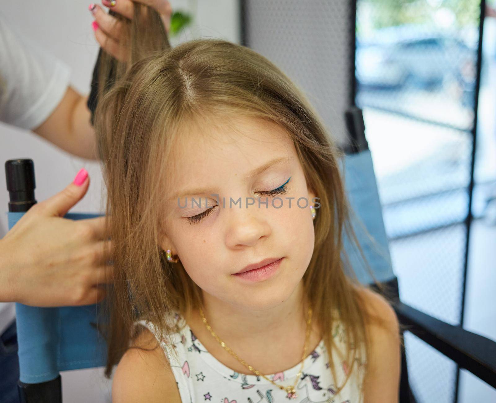 Hairdressing services. Reating hairstyle. Hair styling process. Children hairdressing salon by sarymsakov