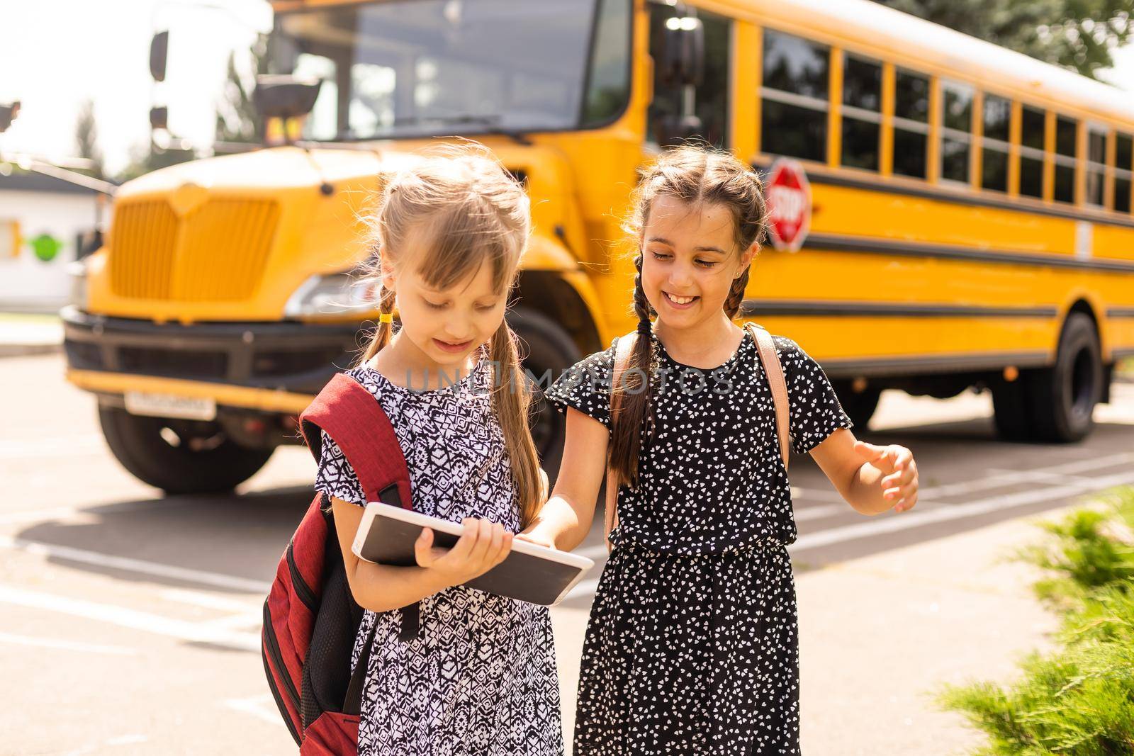 adorable schoolchildren running to school bus.