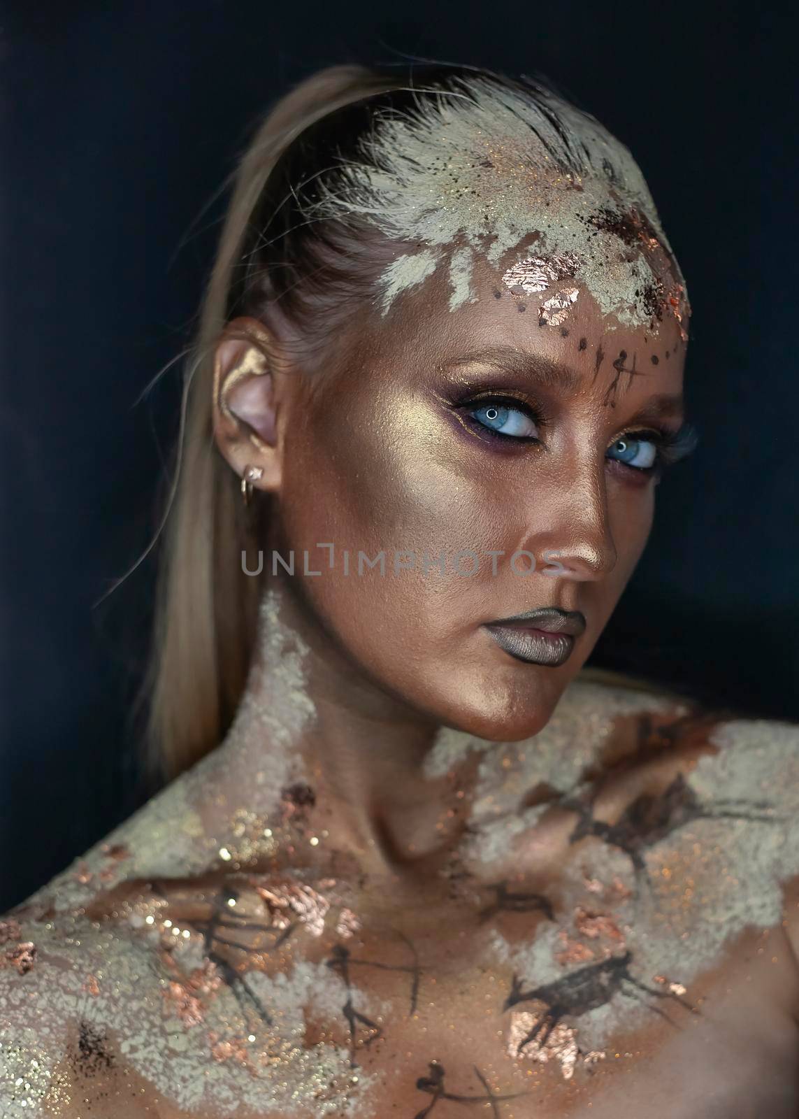 Portrait of female model with creative prehistoric makeup with cave painting