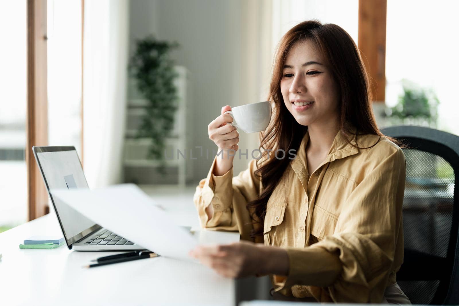 Portrait of smiling beautiful business asian woman with working in modern office desk using computer, Business people employee freelance online marketing e-commerce chart analysis concept