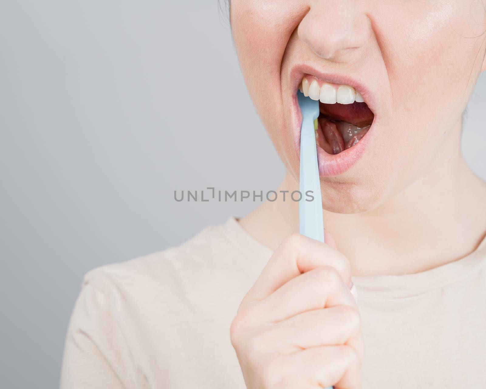 Close-up portrait of caucasian woman brushing her teeth. The girl performs the morning oral hygiene procedure.