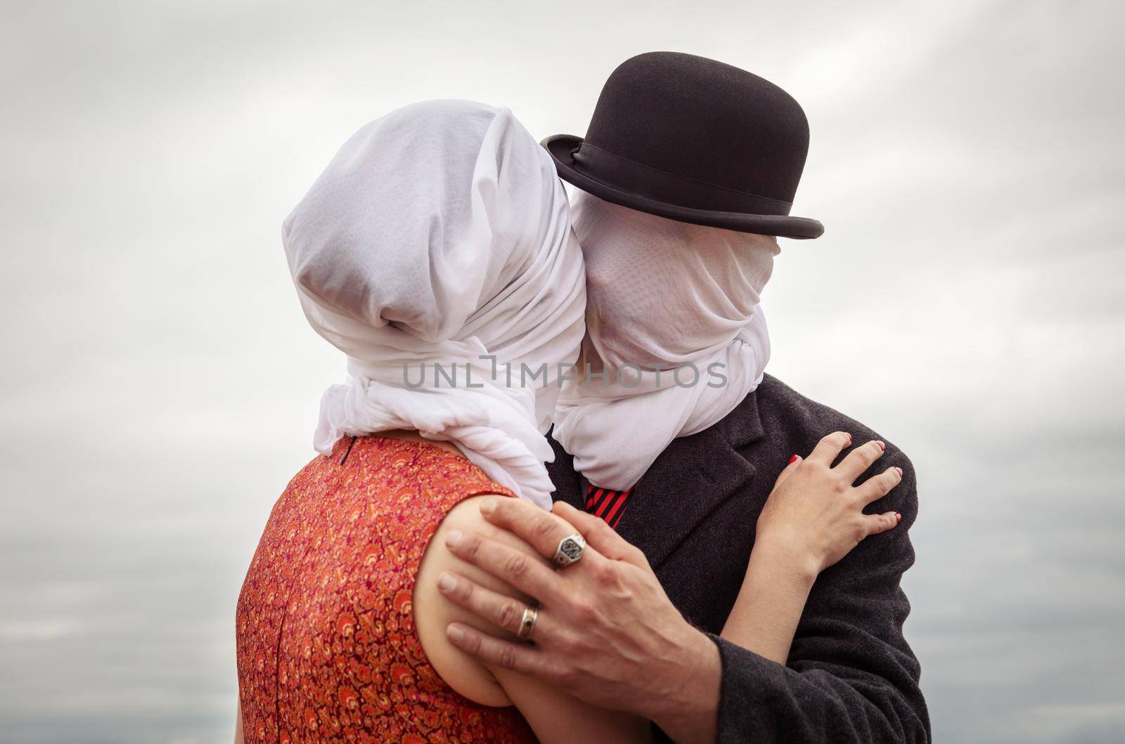 Man kissing woman with white fabrics on their heads by palinchak