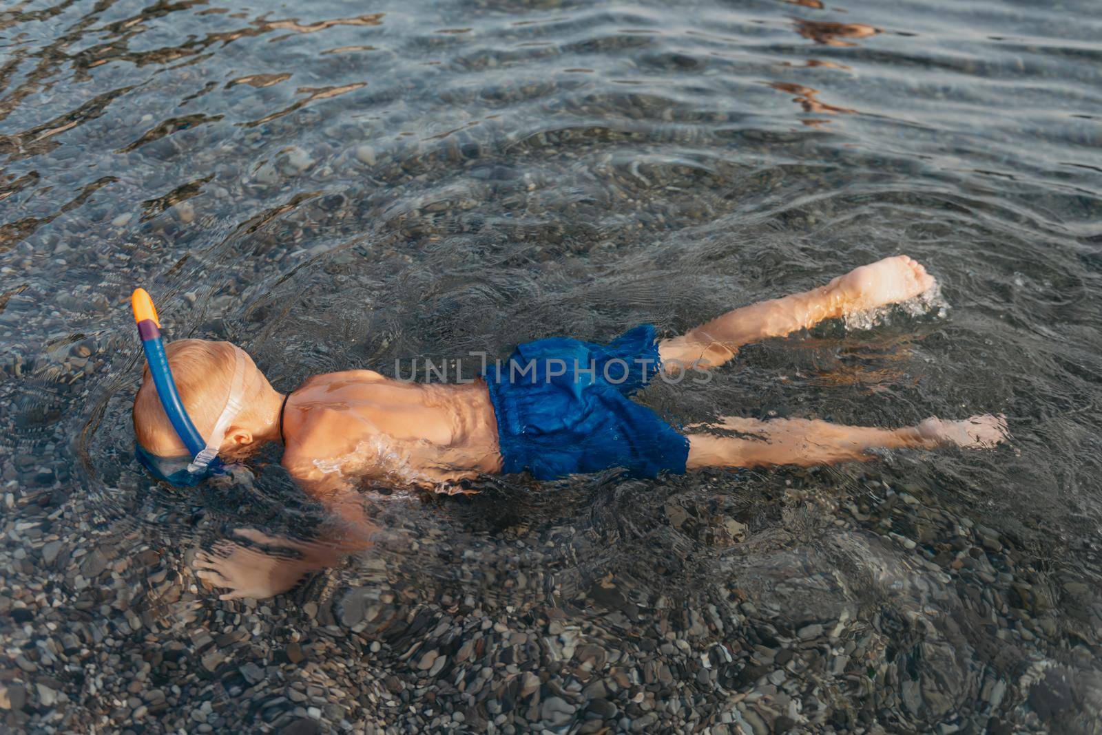 Cute happy little boy swimming and snorking in the sea. Child wearing snorkeling mask diving underwater, little boy enjoy swim underwater on tropical resort by Andrii_Ko