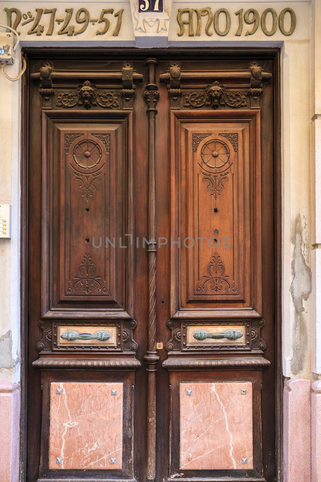 Cartagena, Murcia, Spain- July 18, 2022: Old wooden and marble door with beautiful iron door handle
