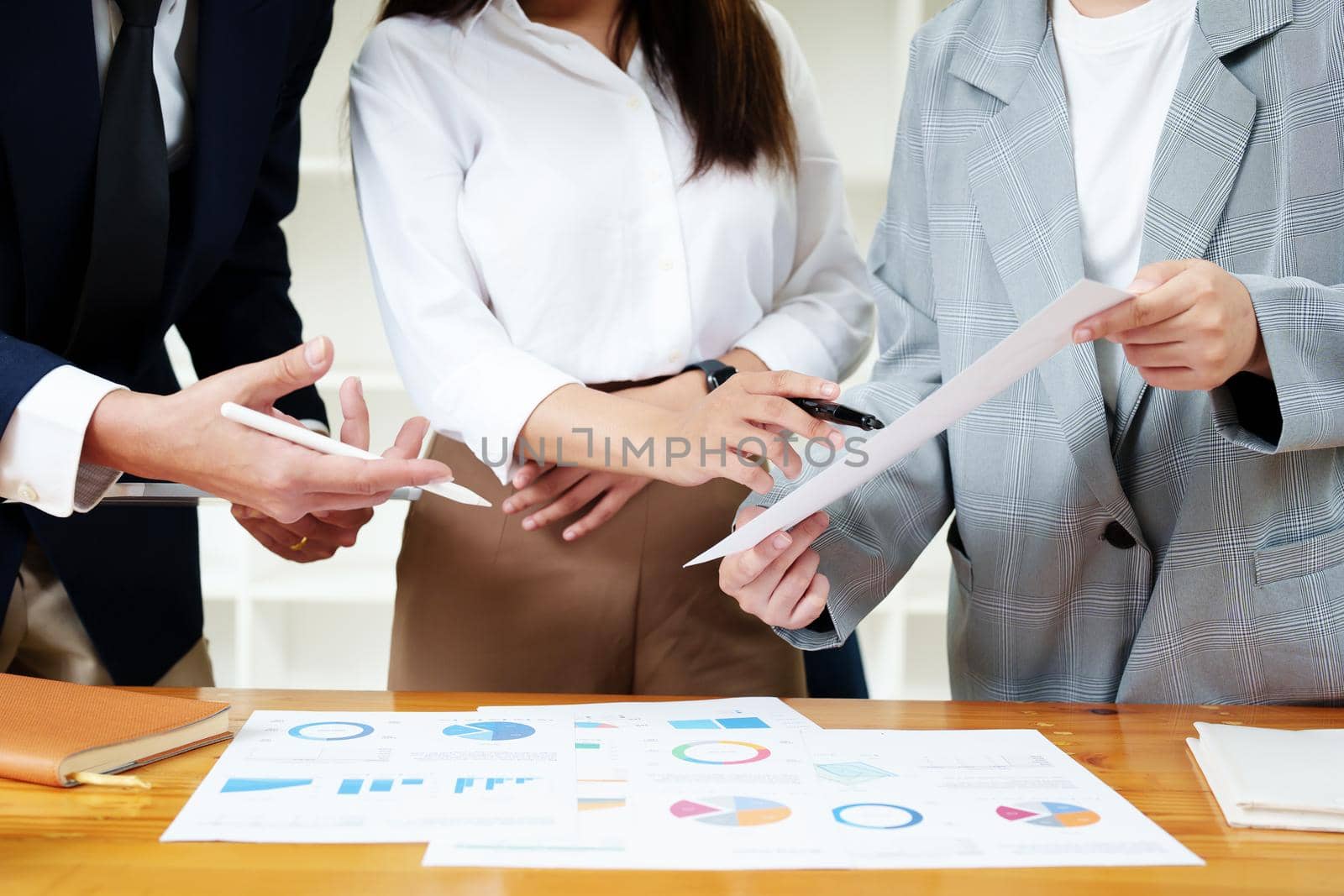 Planning to reduce investment risks, the image of a group of businesspeople working with partners is adjusting marketing strategies to analyze profitable and targeted customer needs at meetings by Manastrong