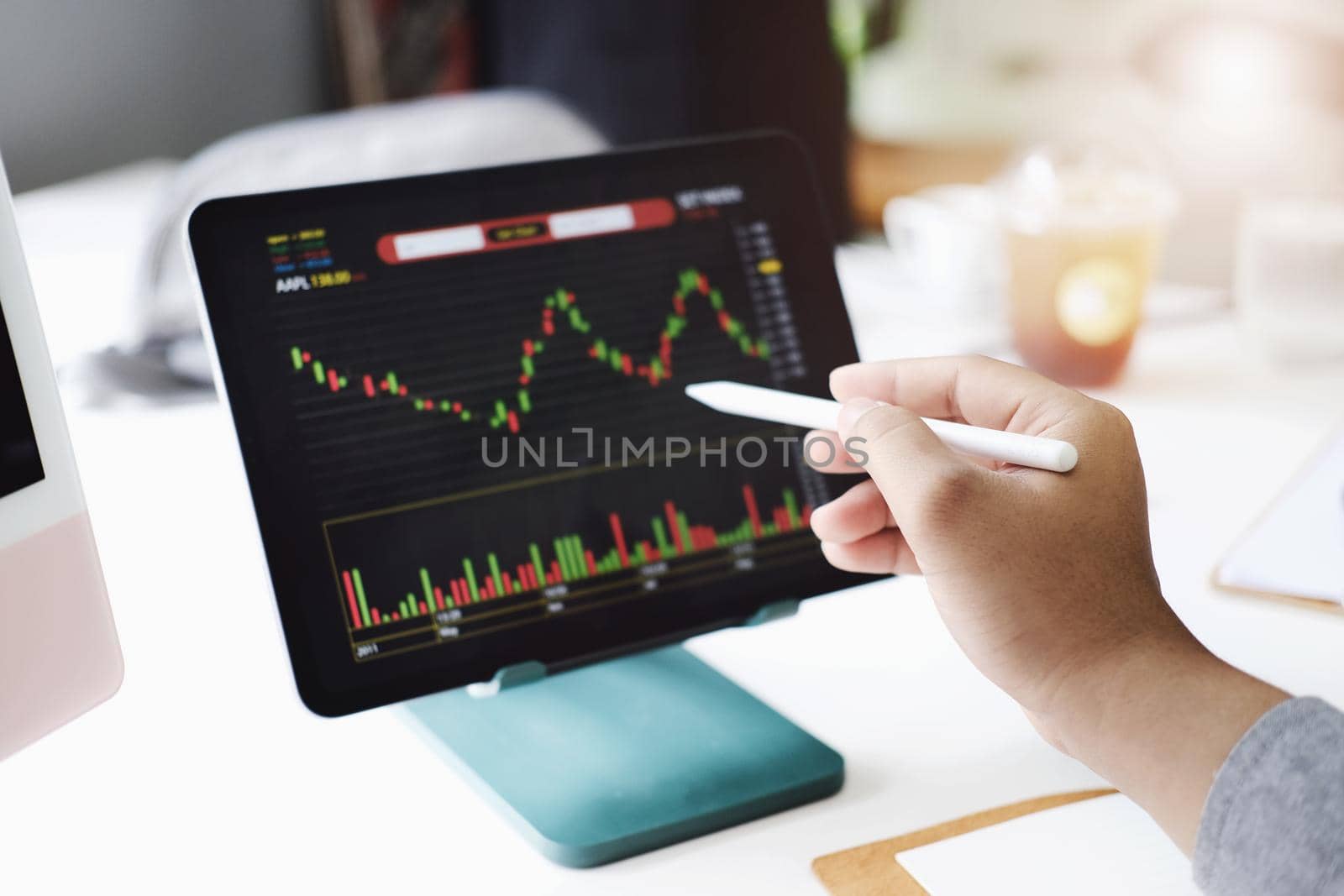 Investment professionals point their pen at their computer monitor to analyze the stock market for profit