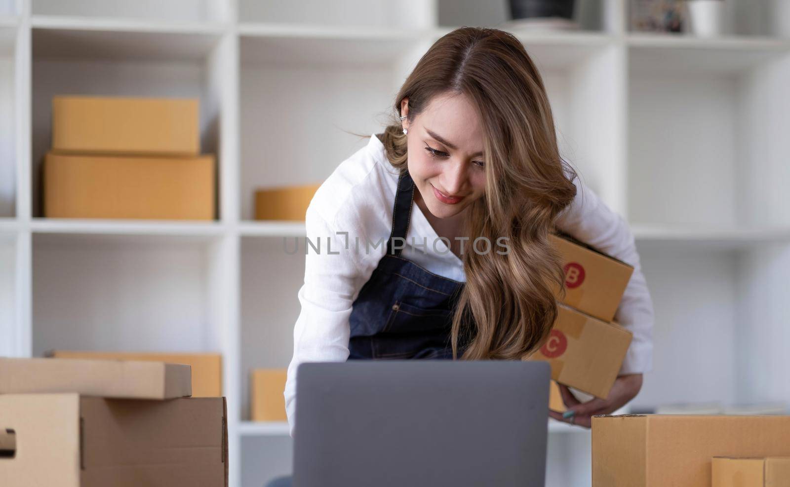 Portrait of Starting small businesses SME owners female entrepreneurs working on receipt box and check online orders to prepare to pack the boxes, sell to customers, SME business ideas online..