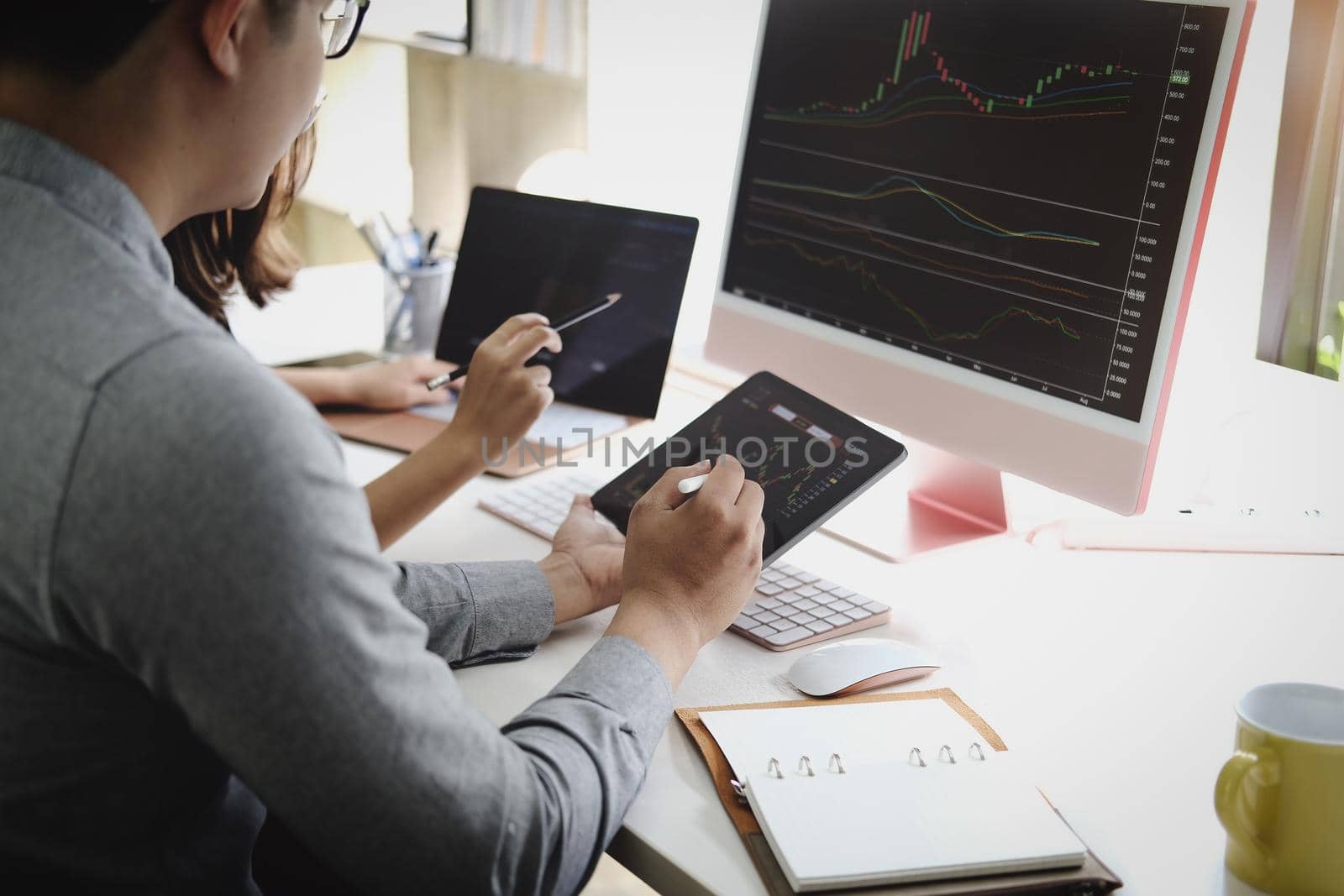 An investment expert points a pen at a computer monitor to analyze the stock market to teach you how to make a profit