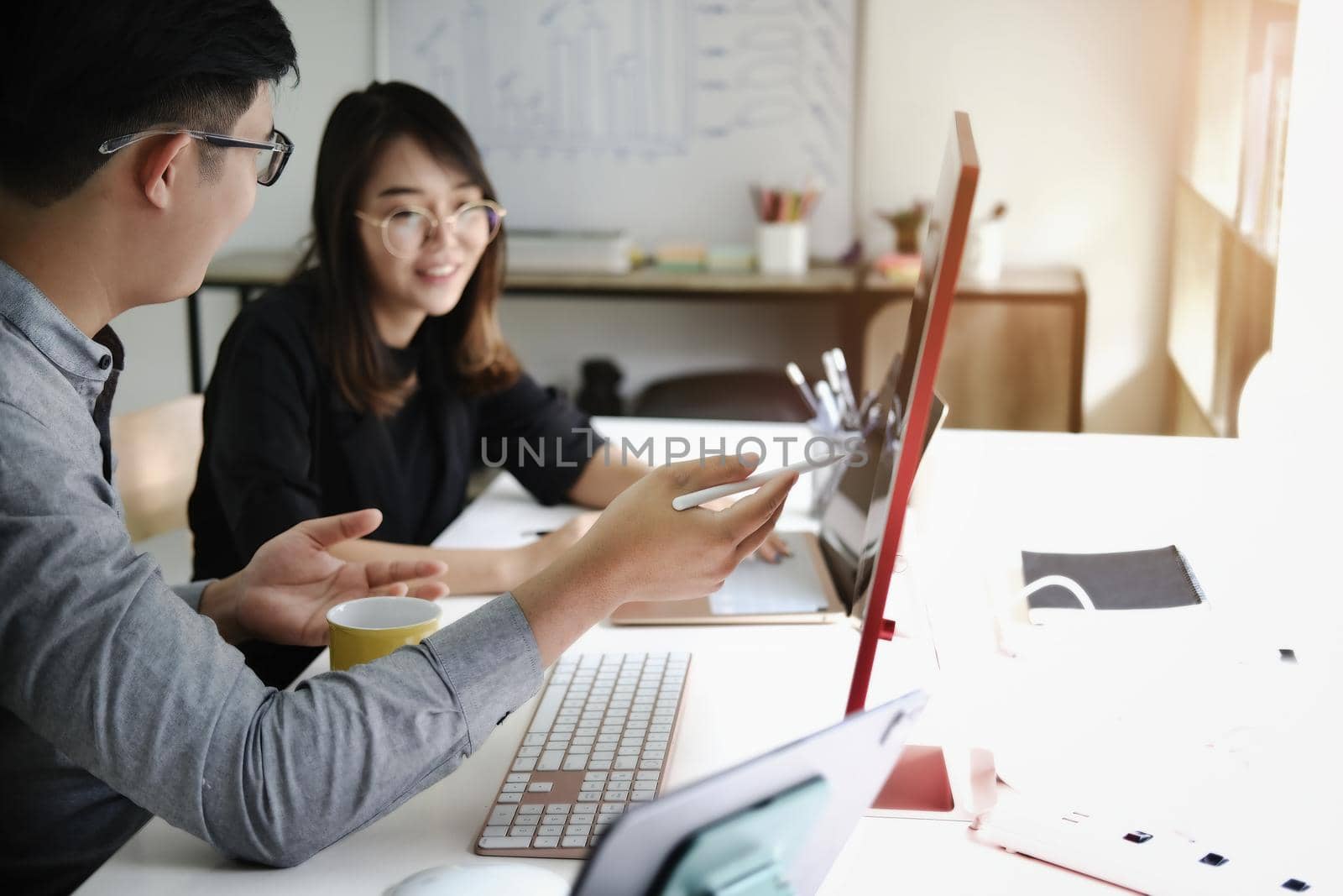 An investment expert points a pen at a computer monitor to analyze the stock market to teach you how to make a profit. by Manastrong