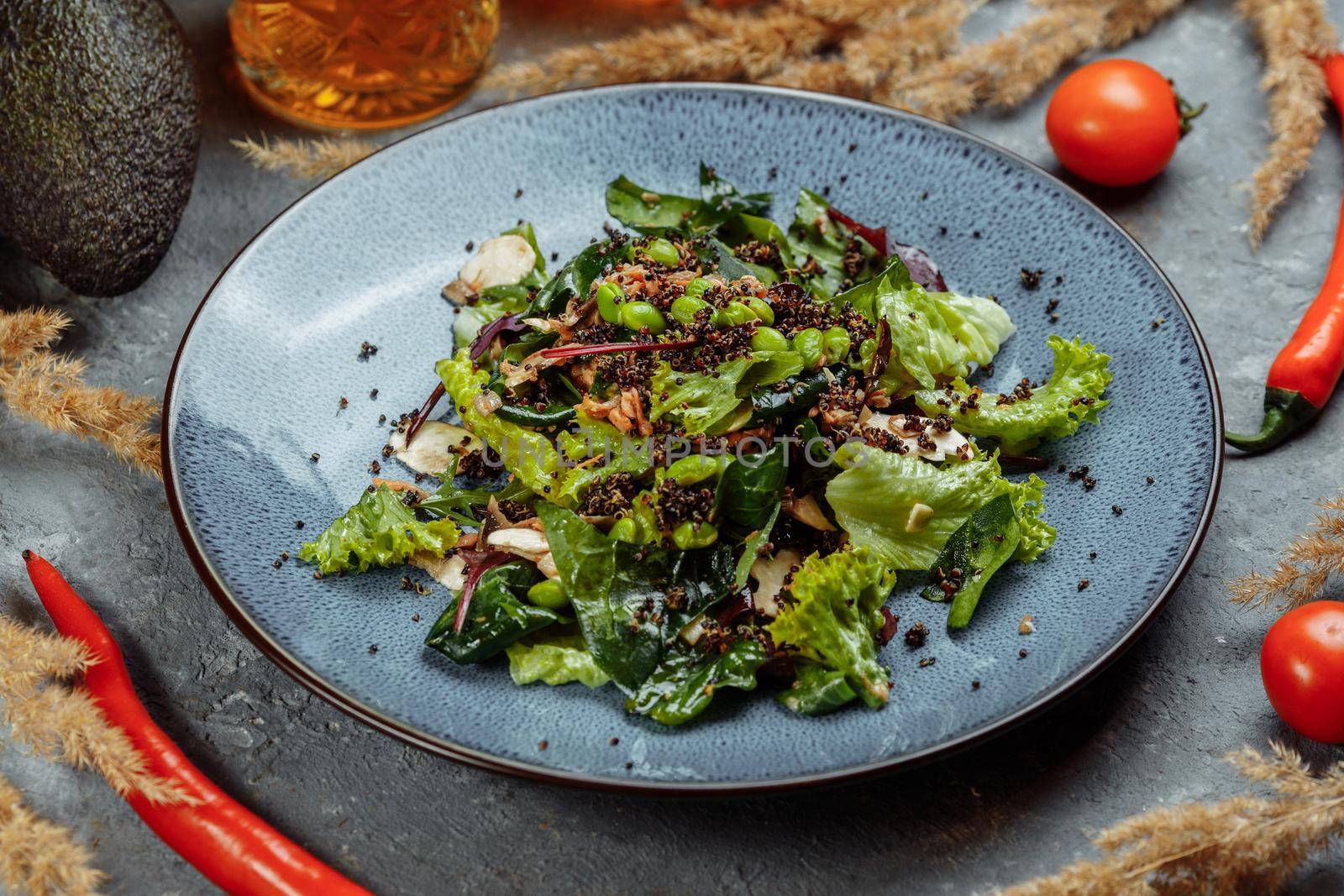 Fresh lamb lettuce salad with avocado, cucumber, salmon, cherry tomatoes. Dressing with honey, dijon mustard, olive oil and lemon juice, topped with chia seeds. Prepared by chef.