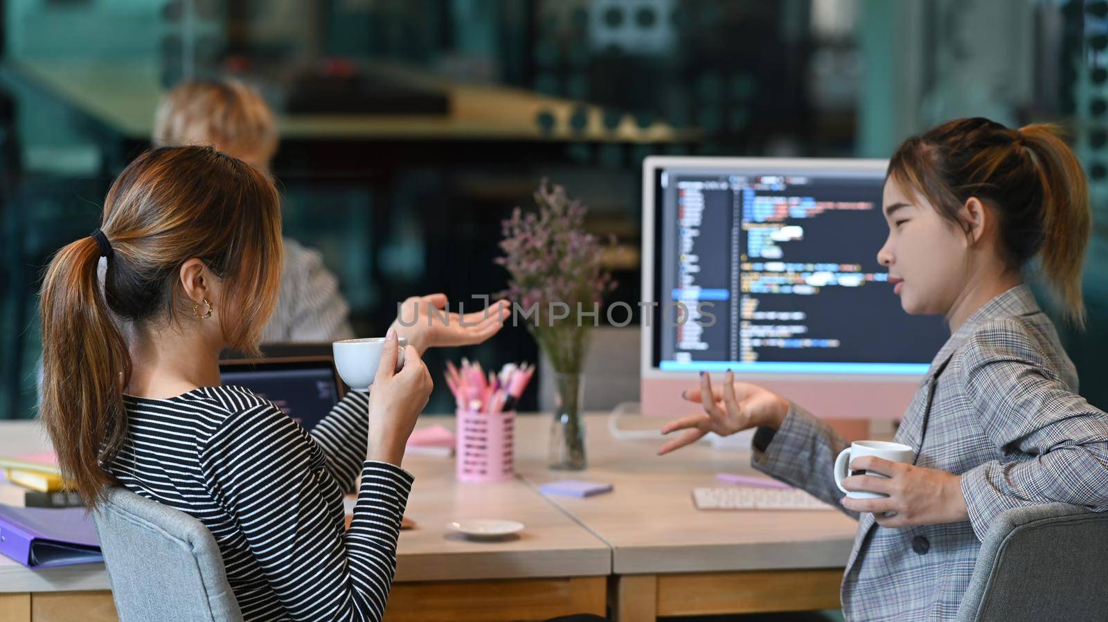 Focused software developers colleagues discussing and working on web site project together at startup office.