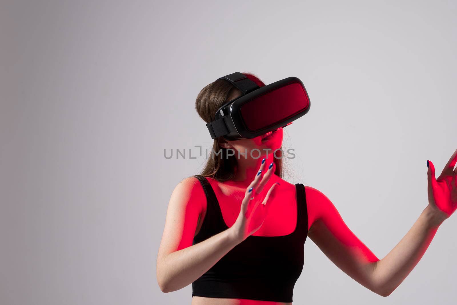 Young woman using virtual reality headset and touching virtual objects. VR, future, gadgets, technology, education online, studying, video game concept. by vovsht