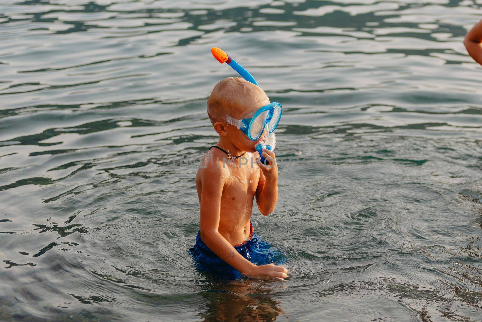 Cute happy little boy swimming and snorking in the sea. Child wearing snorkeling mask diving underwater, little boy enjoy swim underwater on tropical resort