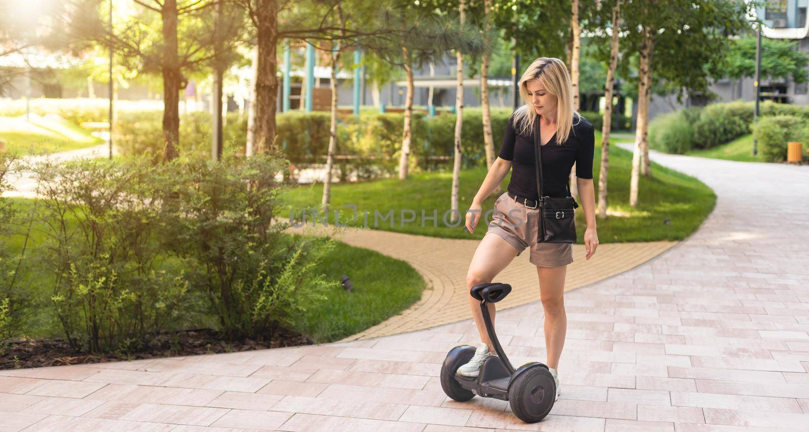 Beautiful woman stand near segway or hoverboard. self balancing electrical scooter