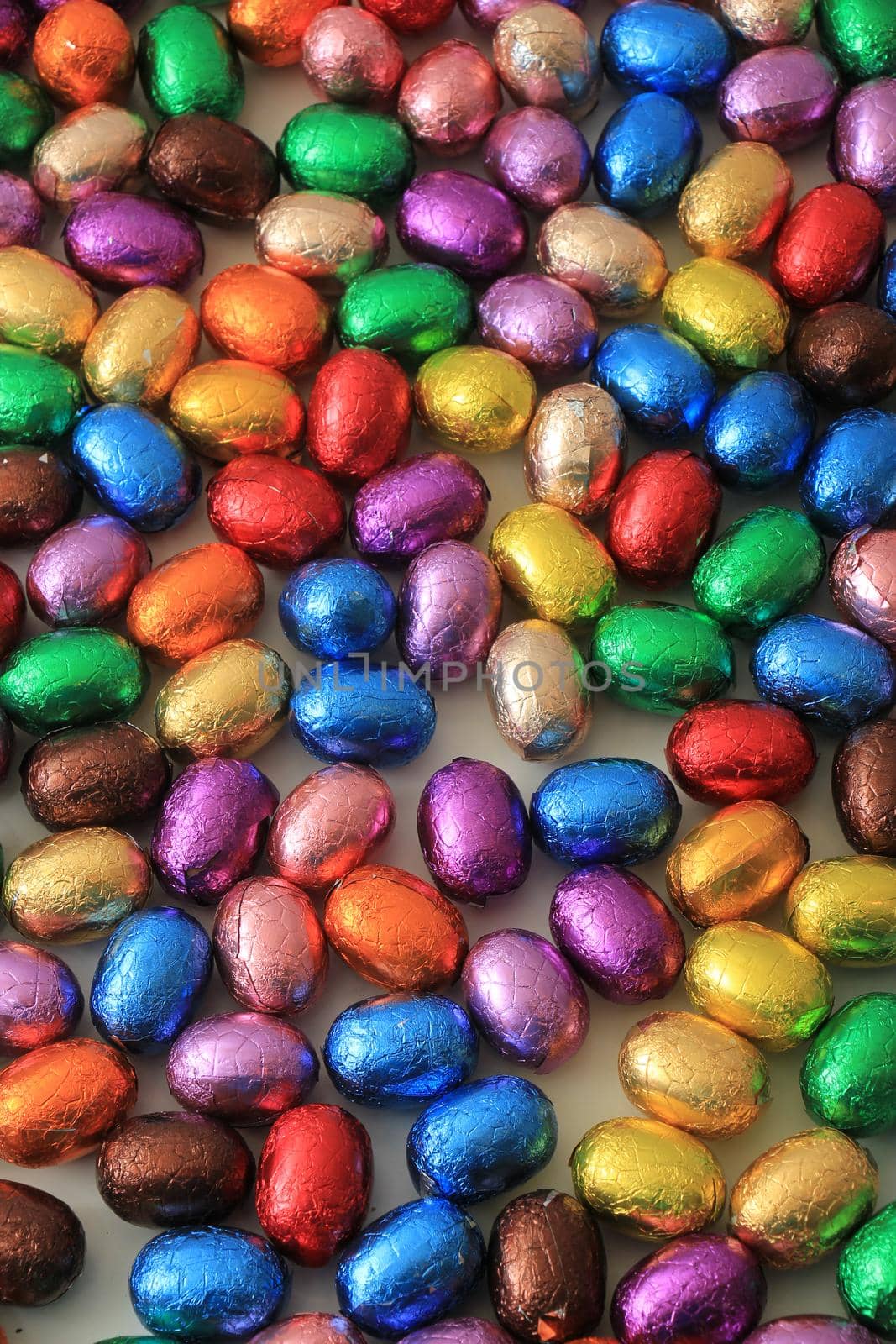 Big pile of colorful wrapped chocolate easter eggs