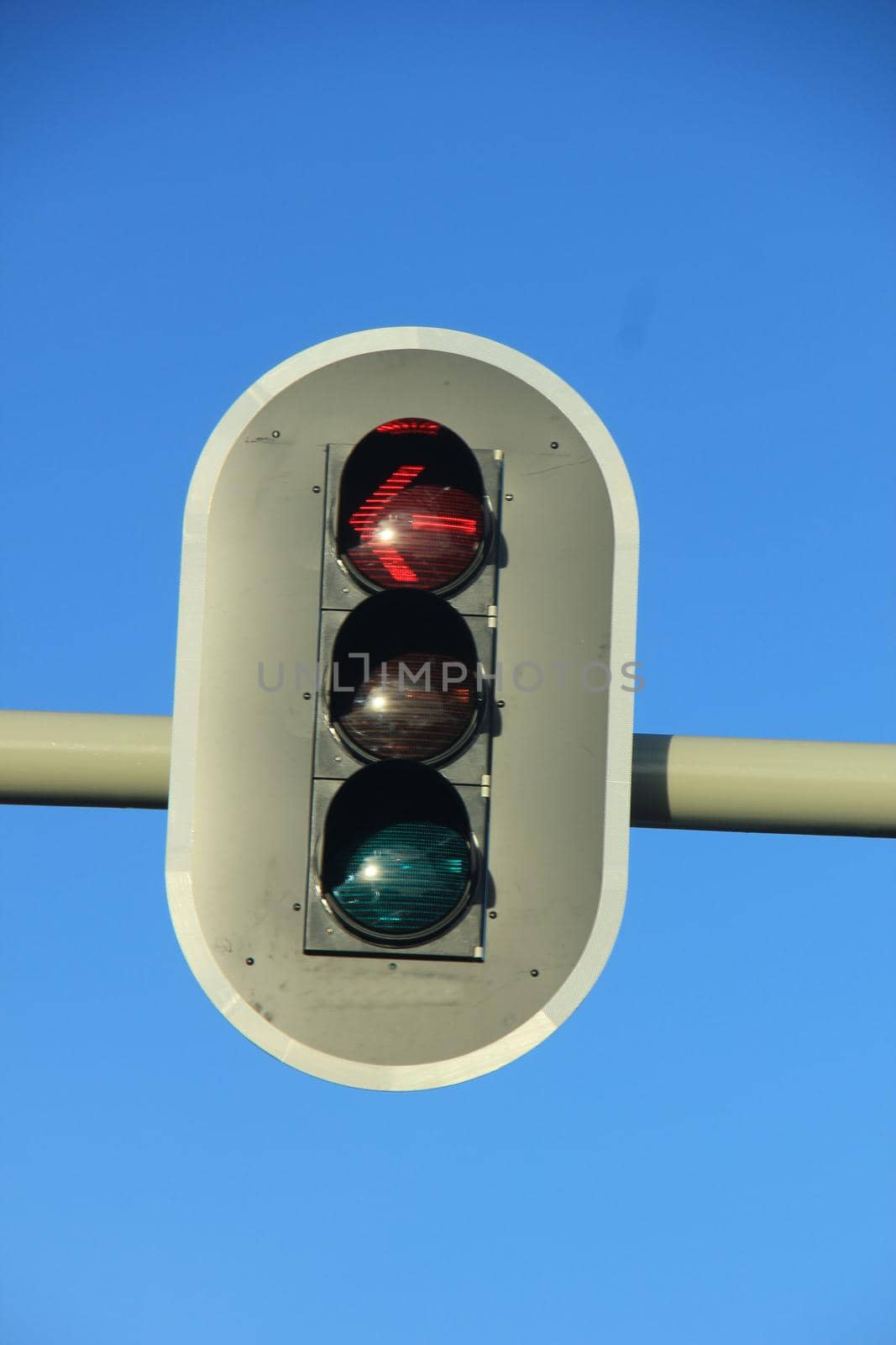 Traffic lights in a clear blue sky by studioportosabbia