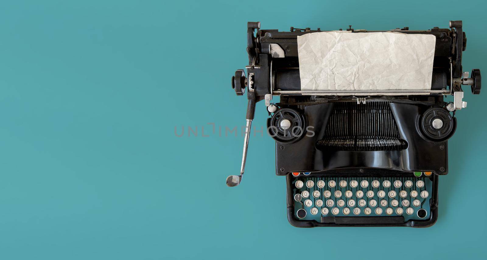 A black vintage typewriter on blue background.