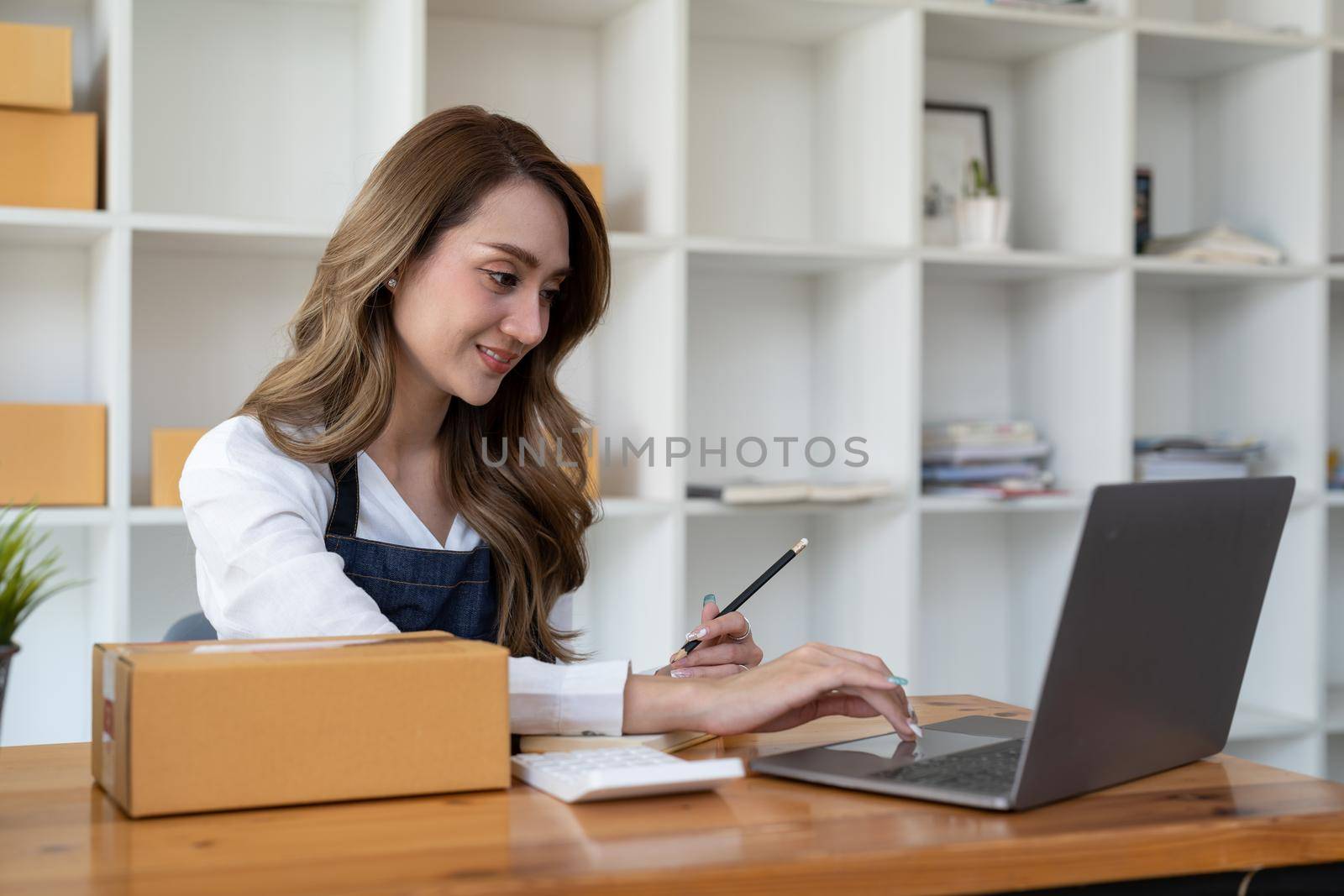 Portrait of young Asian woman working SME with a box at home the workplace.start-up small business owner, small business entrepreneur SME or freelance business online and delivery concept