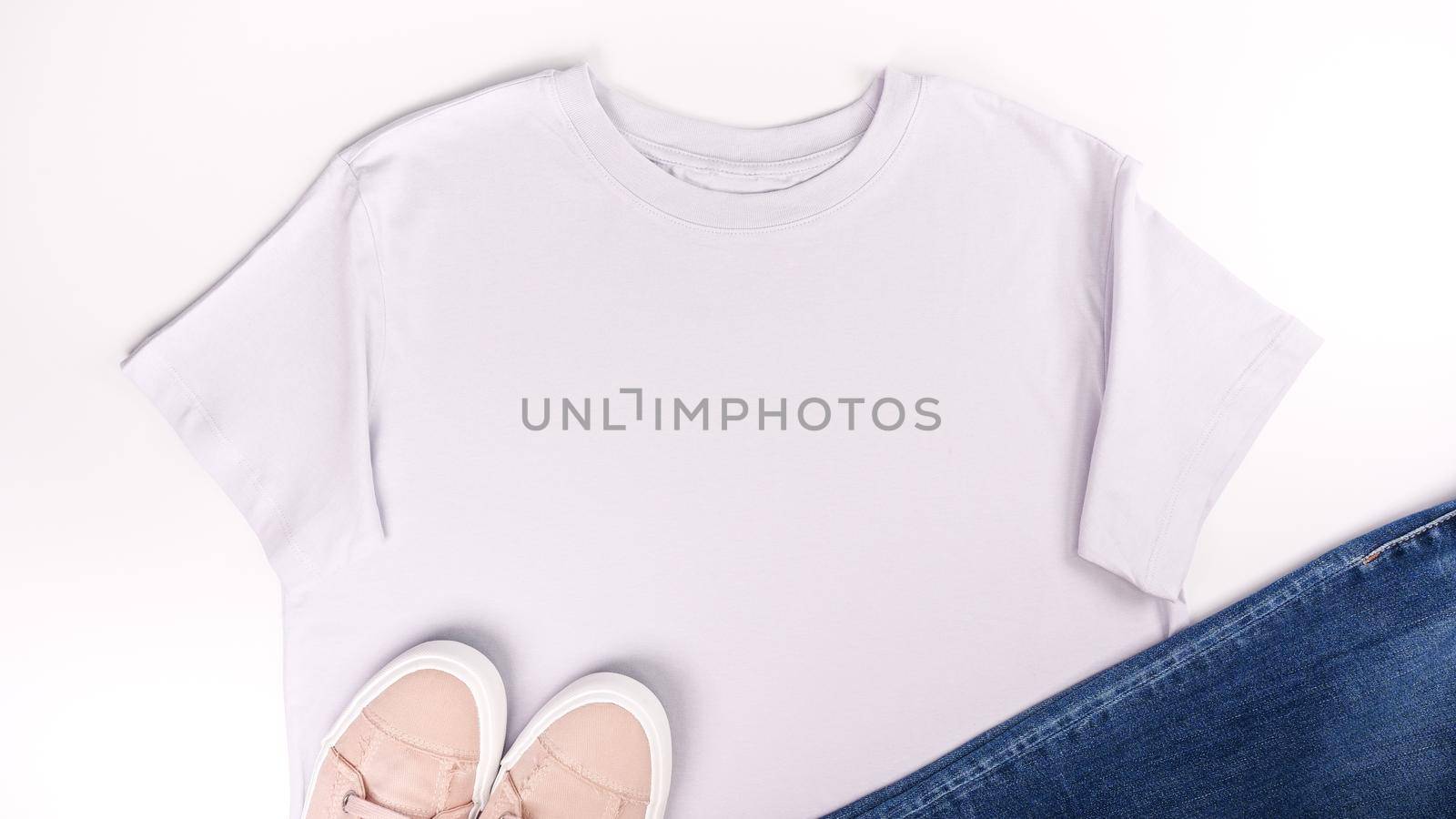 Light grey unisex t shirt mock up flat lay on white background. Top front view t-shirt, snikers, jeans and copy space. Mockup t-shirt and summertime. Template blank shirt