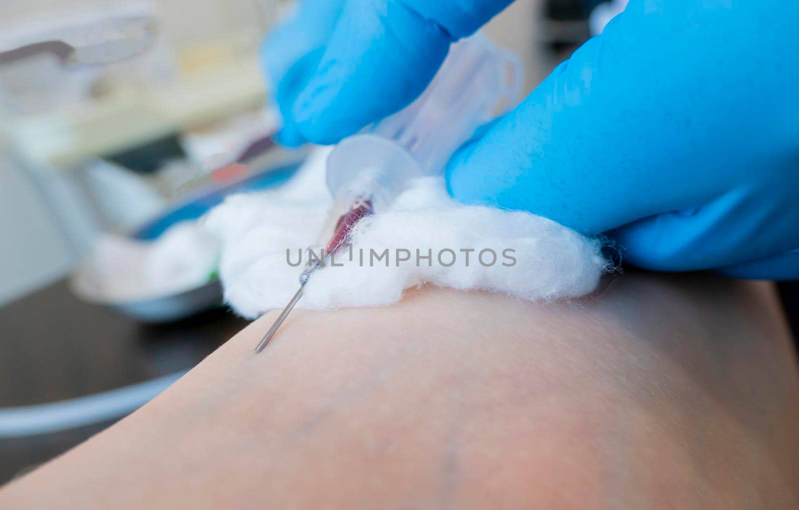 Close up nurse pricking needle syringe in the arm patient drawing blood sample for blood test