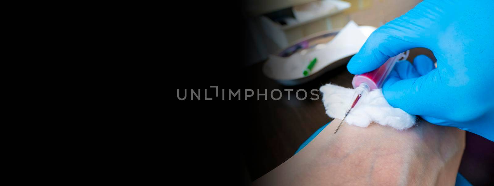 Close up nurse pricking needle syringe in the arm patient drawing blood sample for blood test banner with space for text