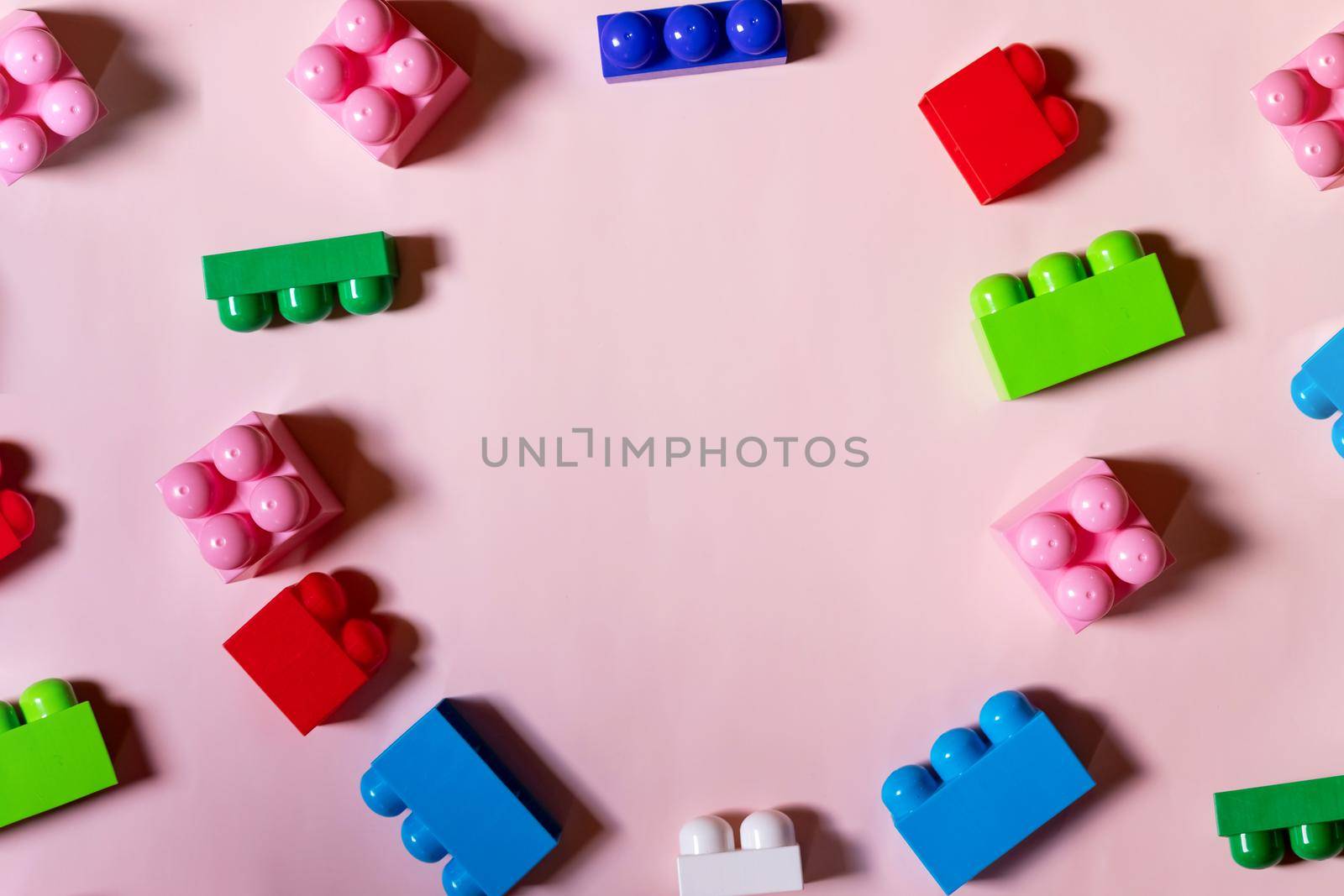 Colorful plastic building blocks flat lay. Yellow background. Child developing game. Pattern