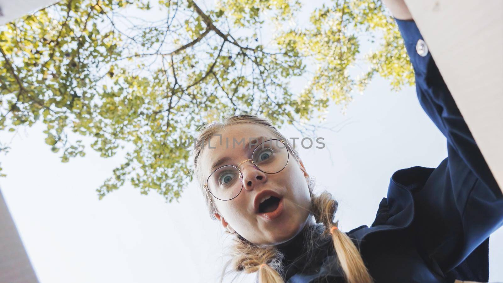 A girl opens a box in the park in admiration