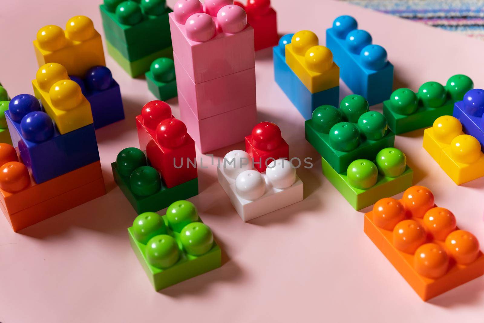 Colorful plastic construction blocks on white background as kids toys frame