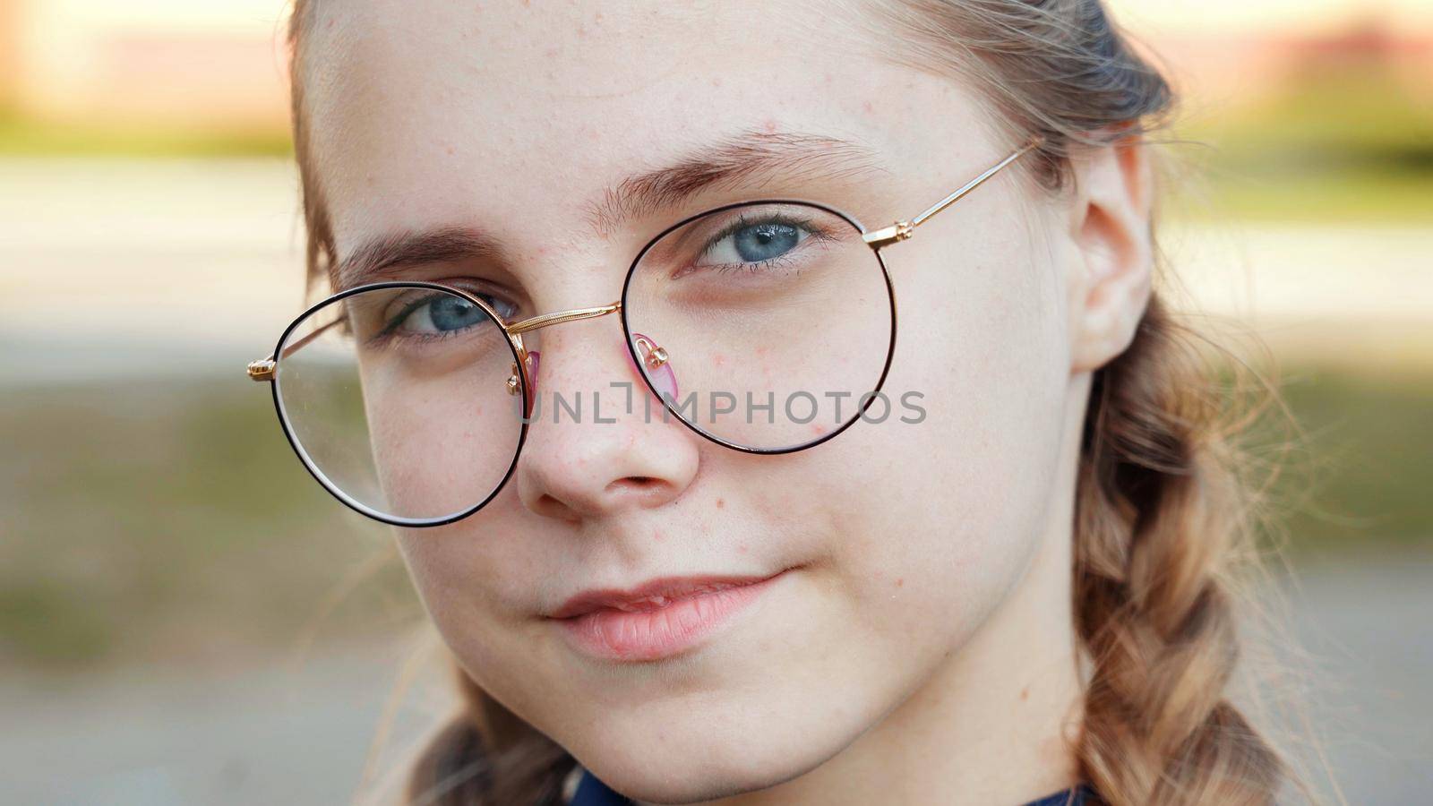 A teenage girl wearing glasses. Close-up of her face