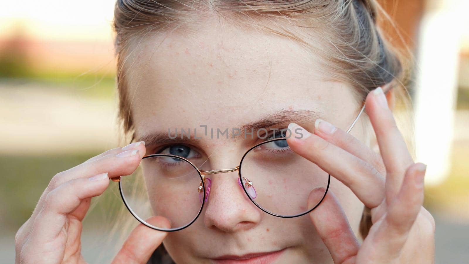 A teenage girl wearing glasses. Close-up of her face