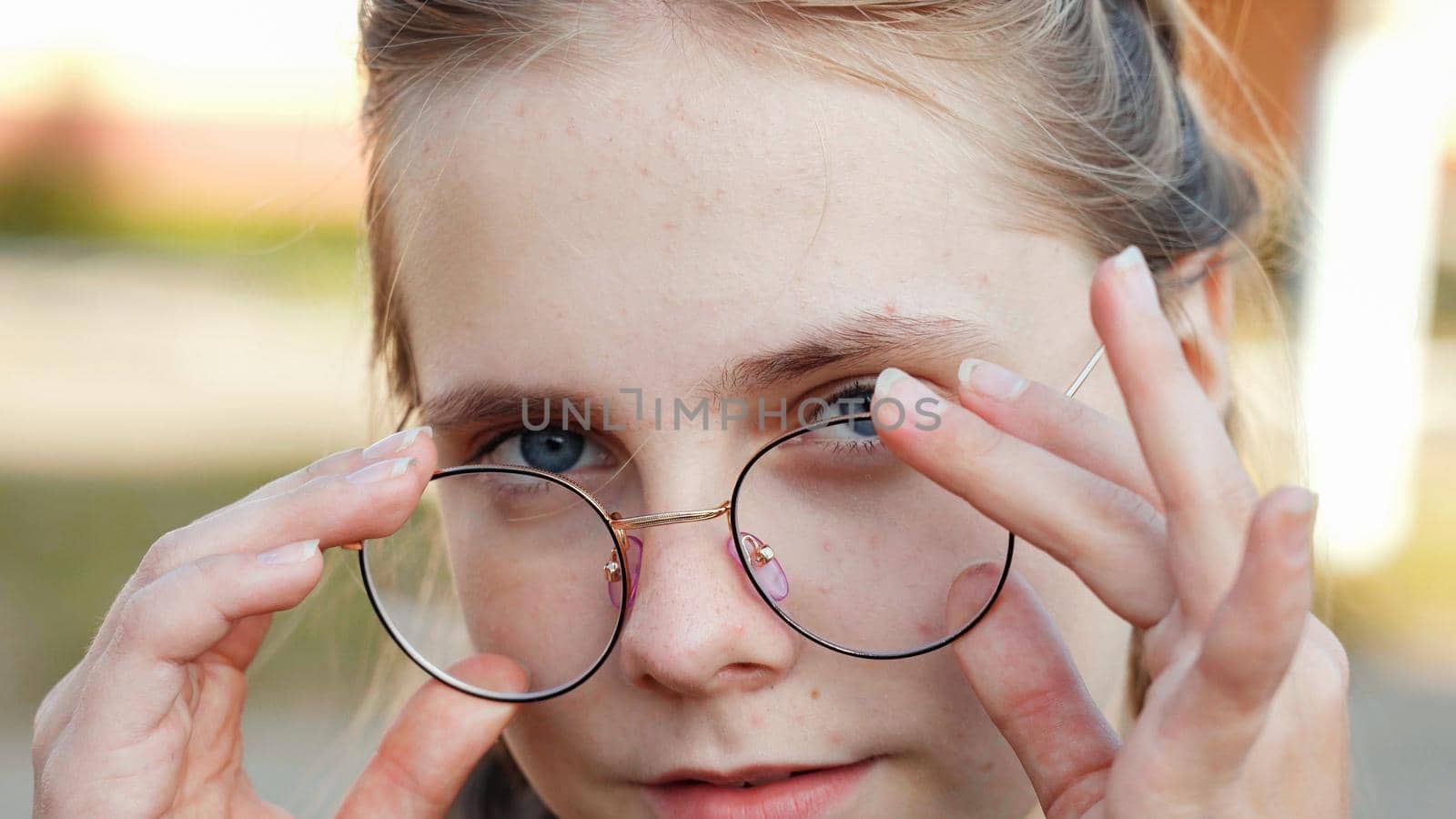 A teenage girl wearing glasses. Close-up of her face