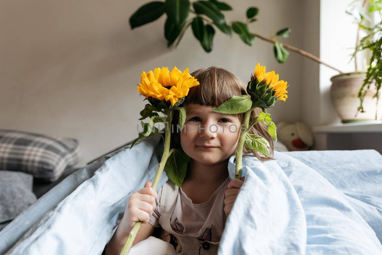 Portrait of a toddler girl holding sunflowers by Varaksina