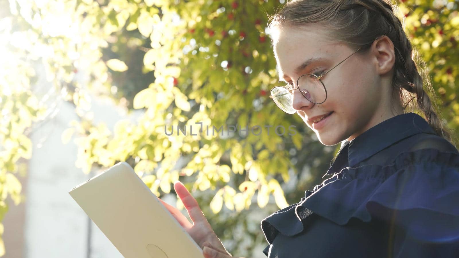 A teenage girl with a tablet in the park