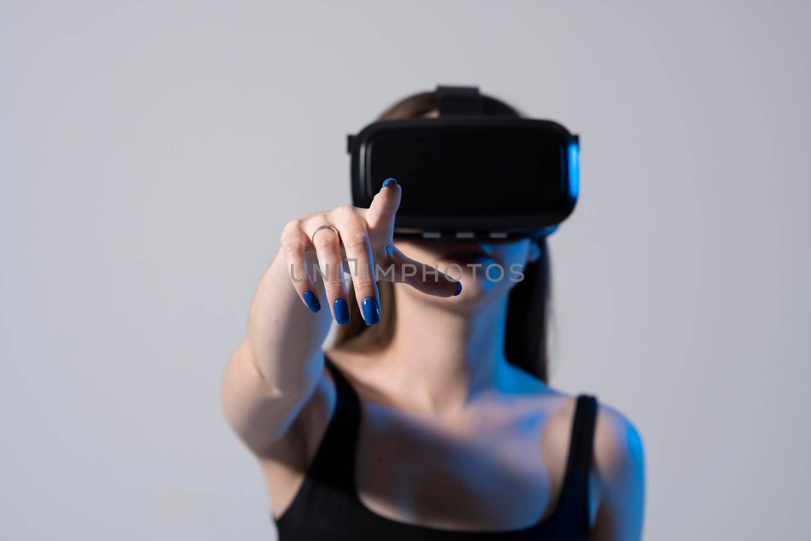 Young woman in virtual reality glasses playing a video game online with a friends