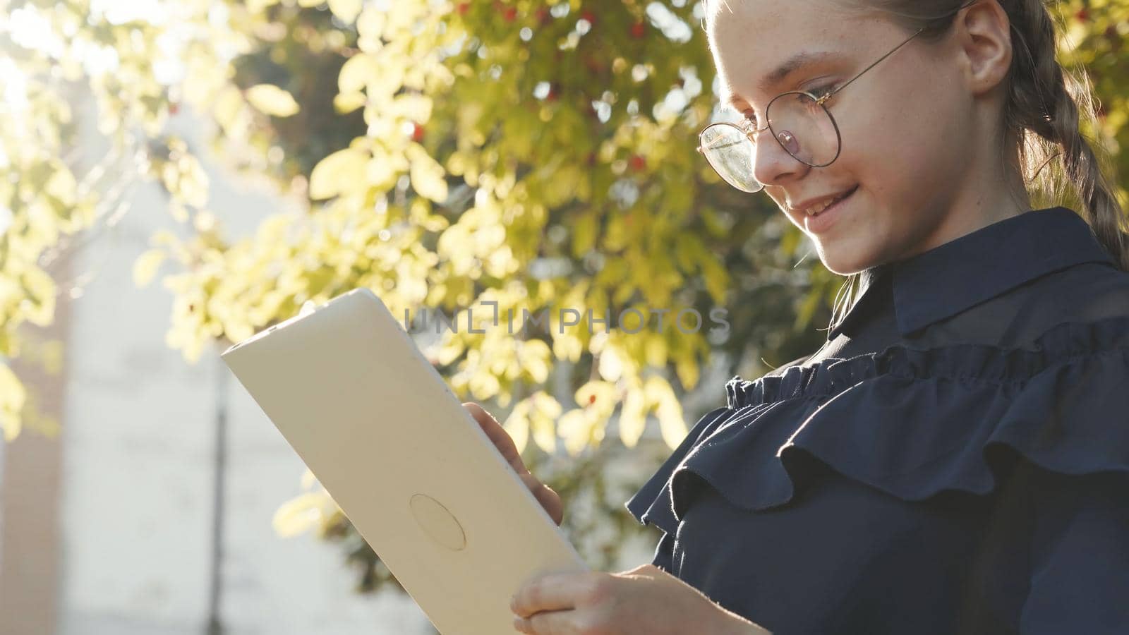 A teenage girl with a tablet in the park