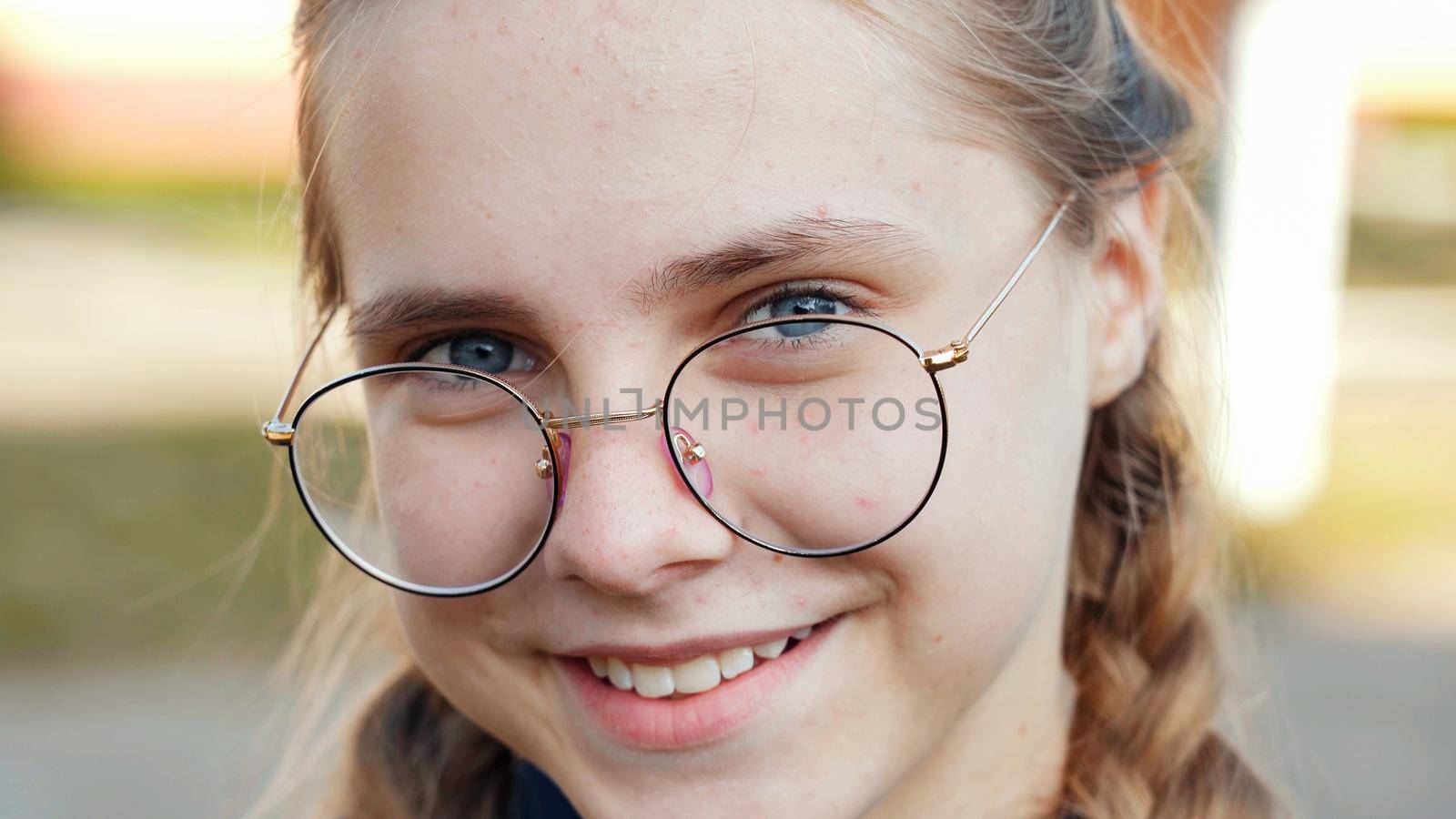 A teenage girl wearing glasses. Close-up of her face