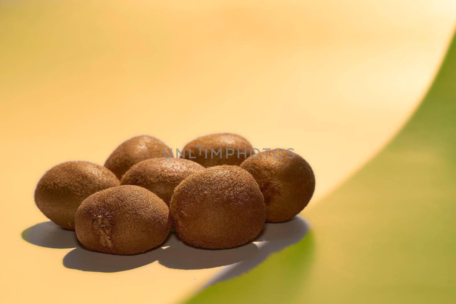 A bunch of sweet sour tasty healthy kiwi fruit on a golden yellow background by jovani68