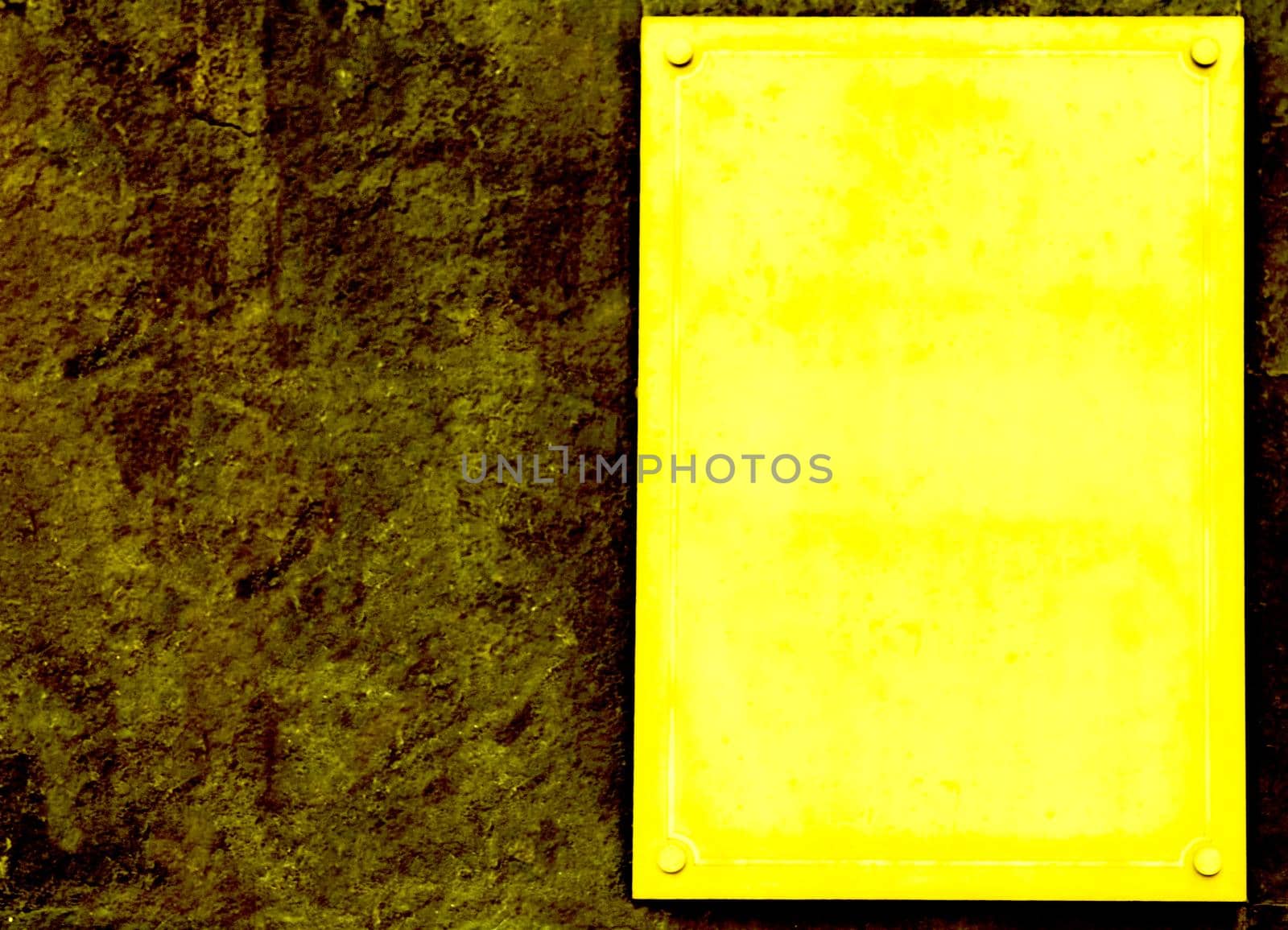 an ornamental tablet, typically of metal, porcelain, or wood, that is fixed to a wall or other surface in commemoration of a person or event.Yellow Plaque with place for text on brown granite wall.