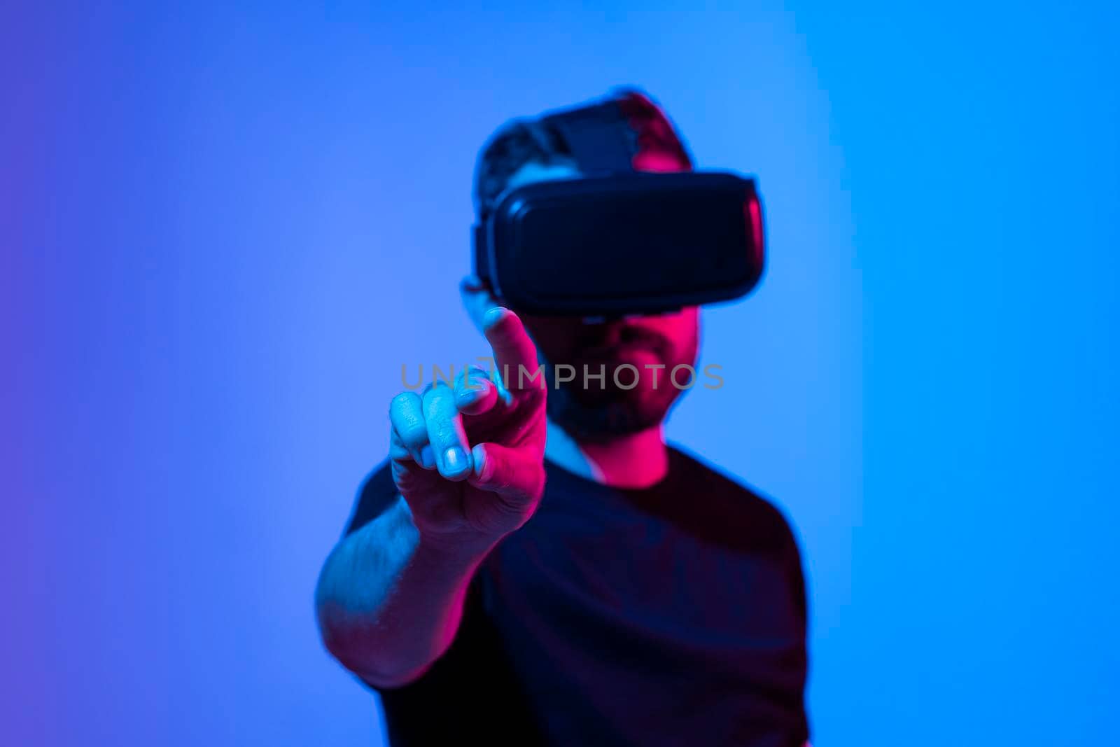 Amazed bearded man in a white t-shirt wearing VR headset. Man play VR video game. Digital future and innovation