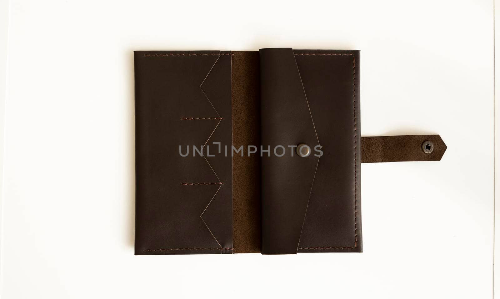 Man's handmade wallet on a white surface. Wallet made of genuine brown leather on a white background. Accessories for men