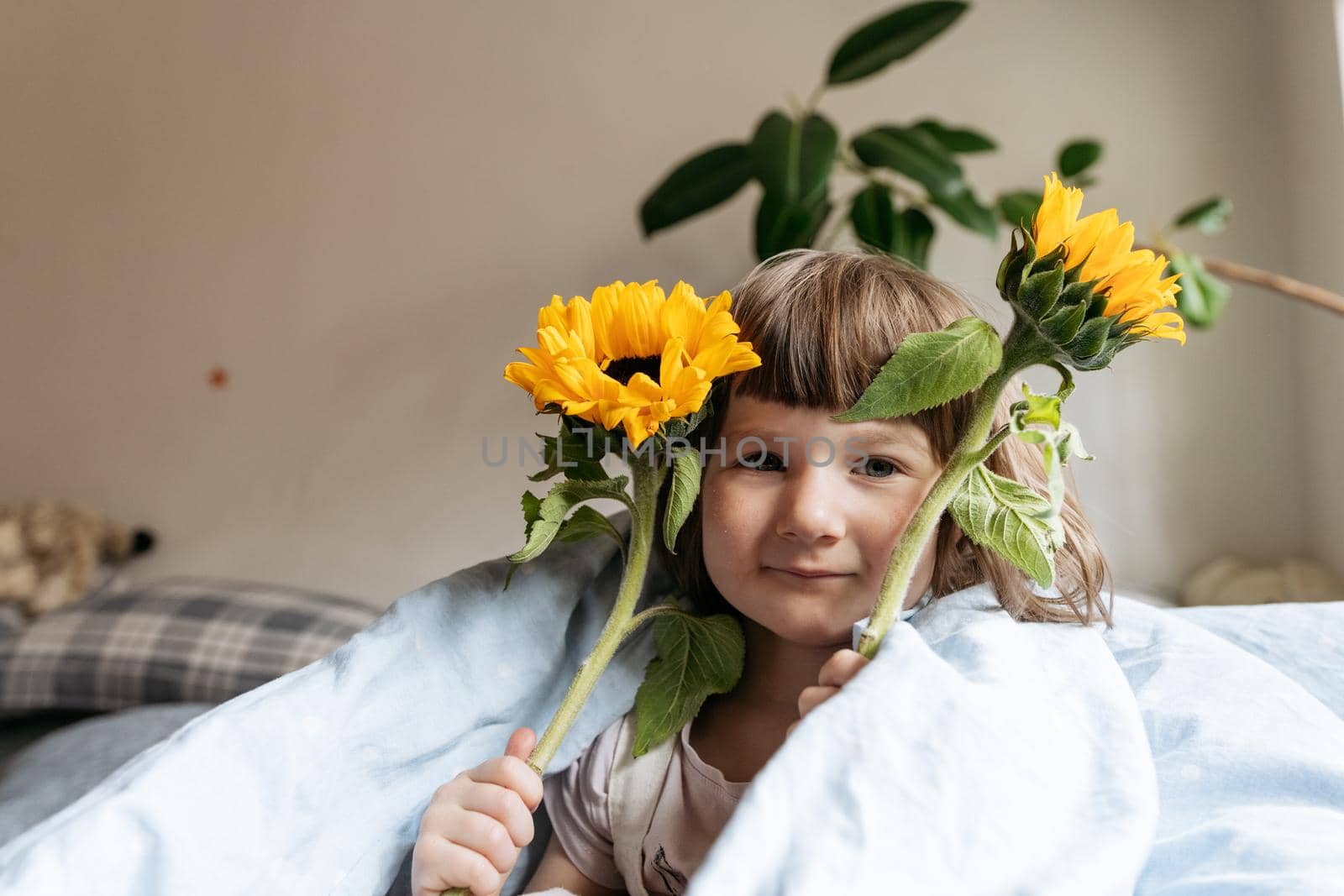 Portrait of a toddler girl holding sunflowers by Varaksina
