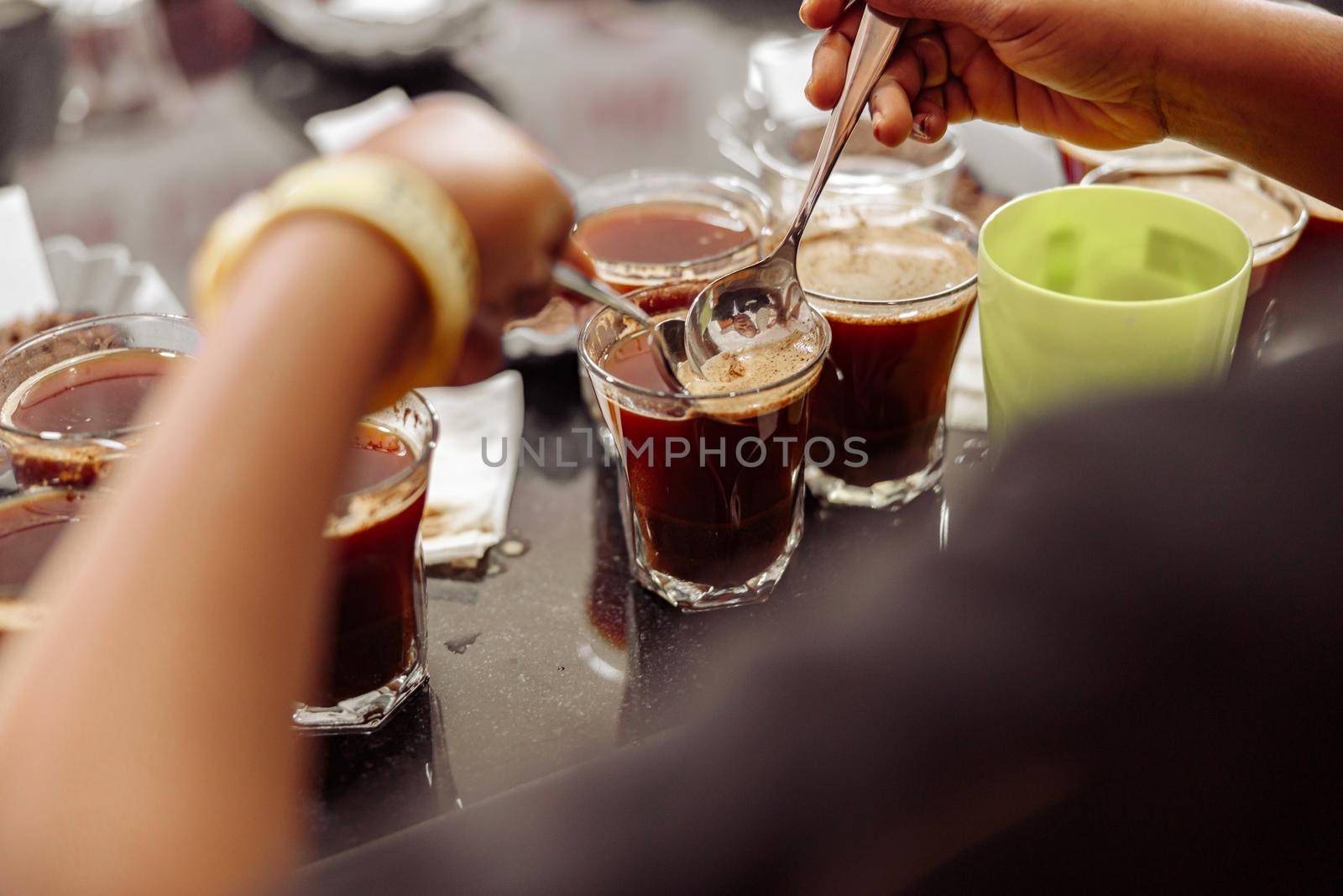 Cup taster man with spoons in hands tasting degustation coffee by Yaroslav_astakhov