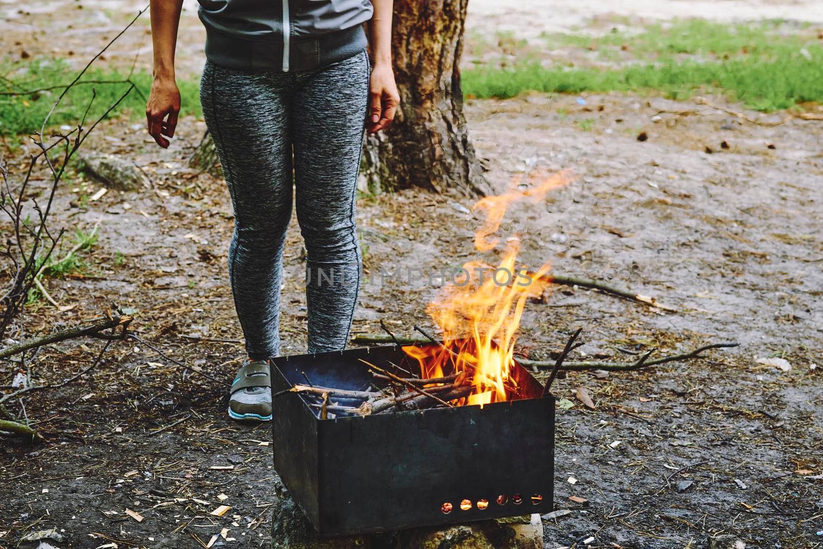 A young girl kindles a barbecue grill for cooking chicken meat and vegetables by jovani68