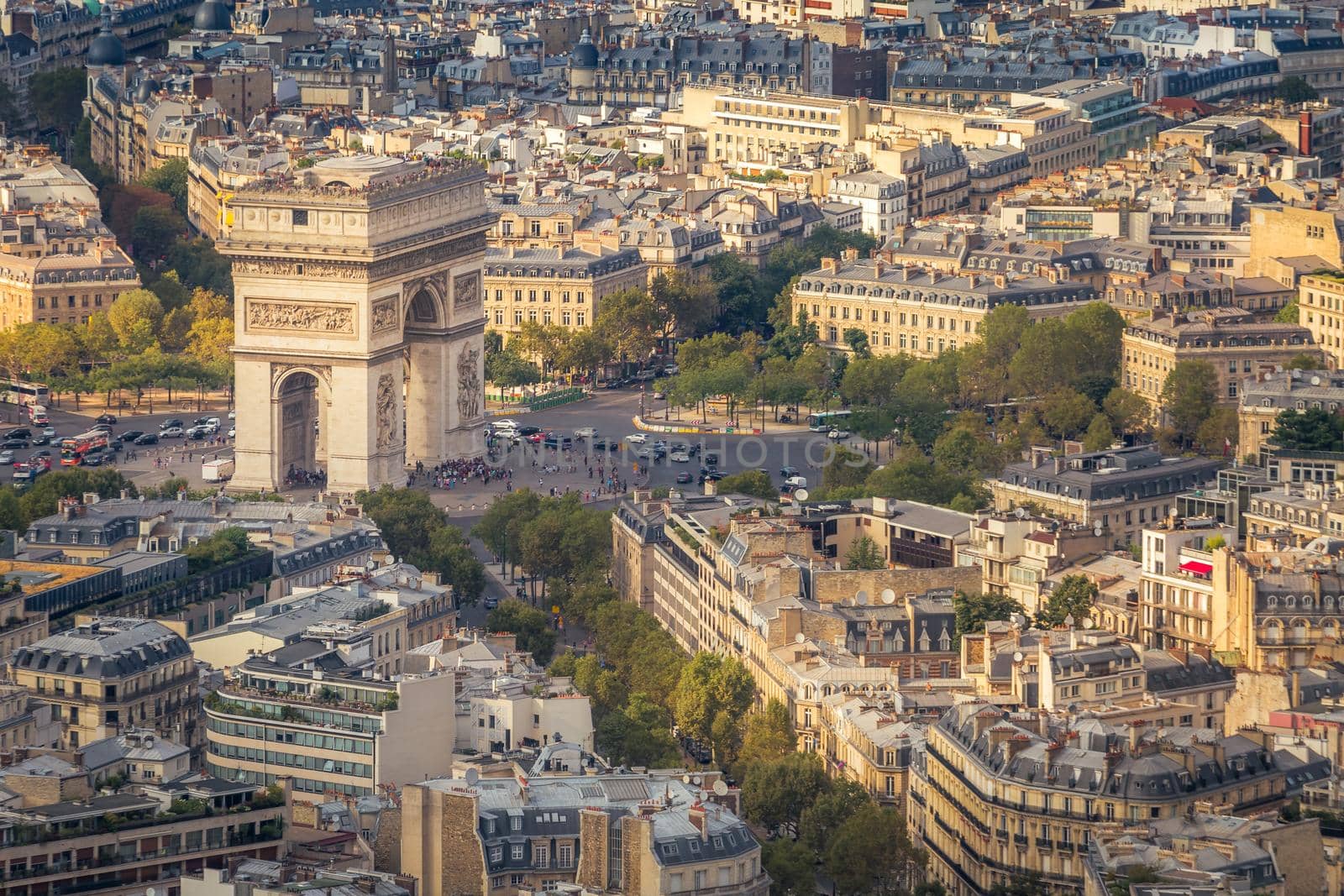 Arc de Triomphe and parisian roofs at golden sunrise Paris, France