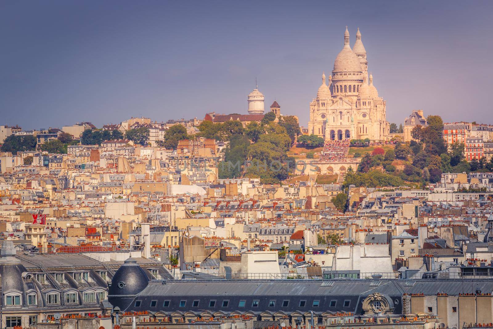Parisian roofs of Montmartre and Sacre Couer at sunset Paris, France