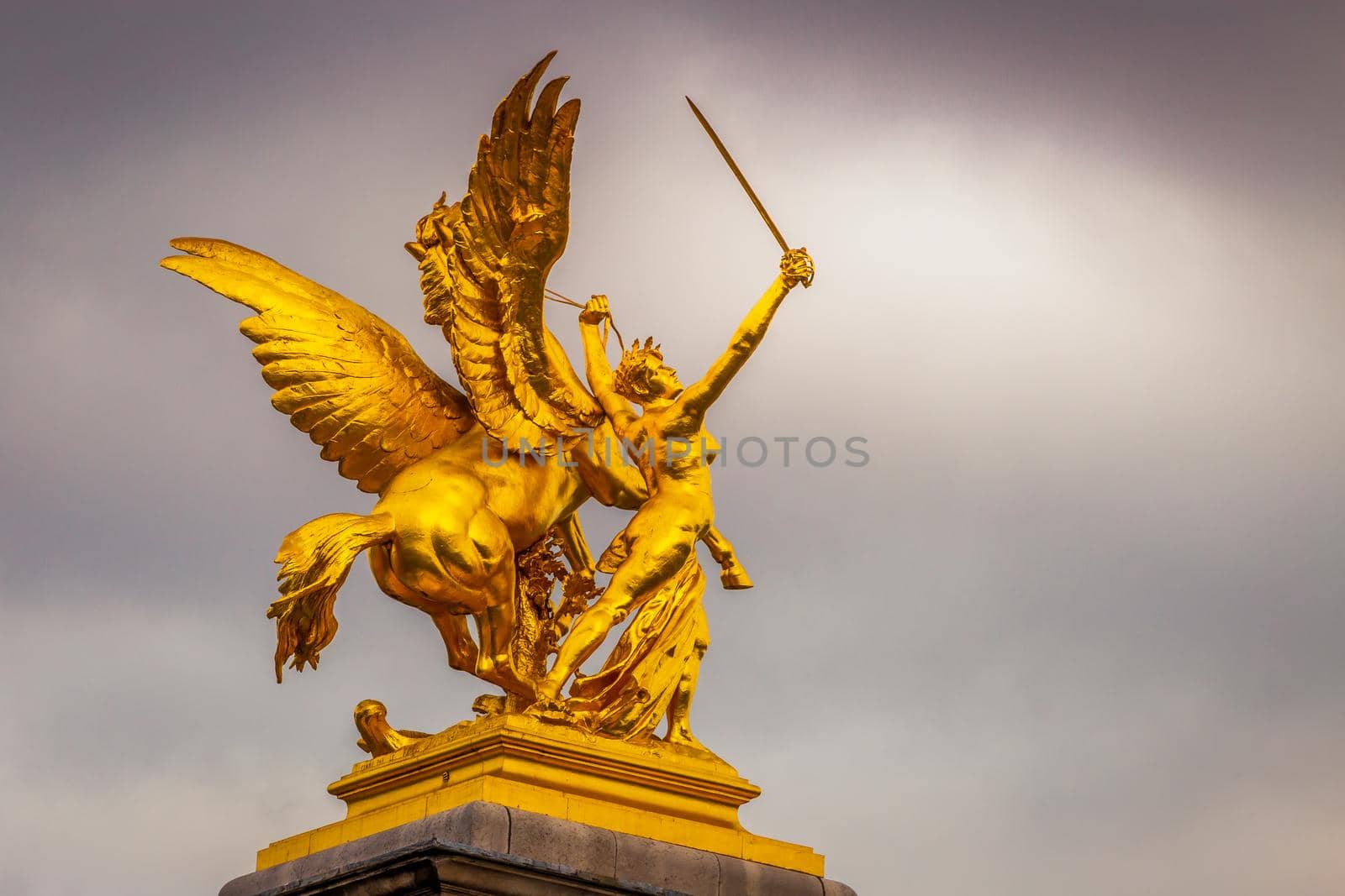 Golden fame Sculpture in Pont Alexandre III at cloudy day, Paris, france