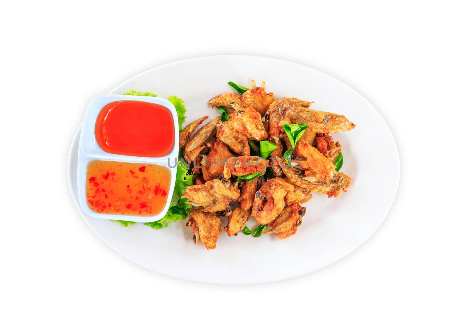 Fried chicken wings with sauce in white plate on white background